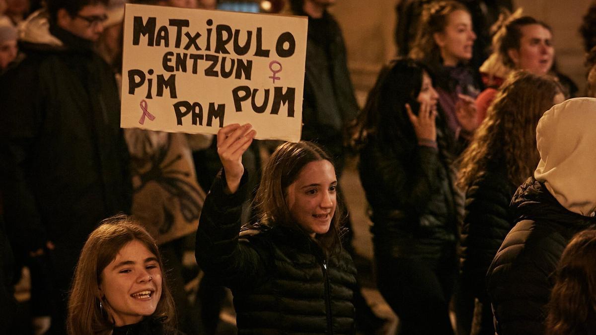 Dos jóvenes, con un cartel reivindicativo.