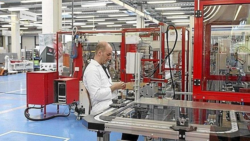 Un operario trabajando en una línea de producción de componentes electrónicos.