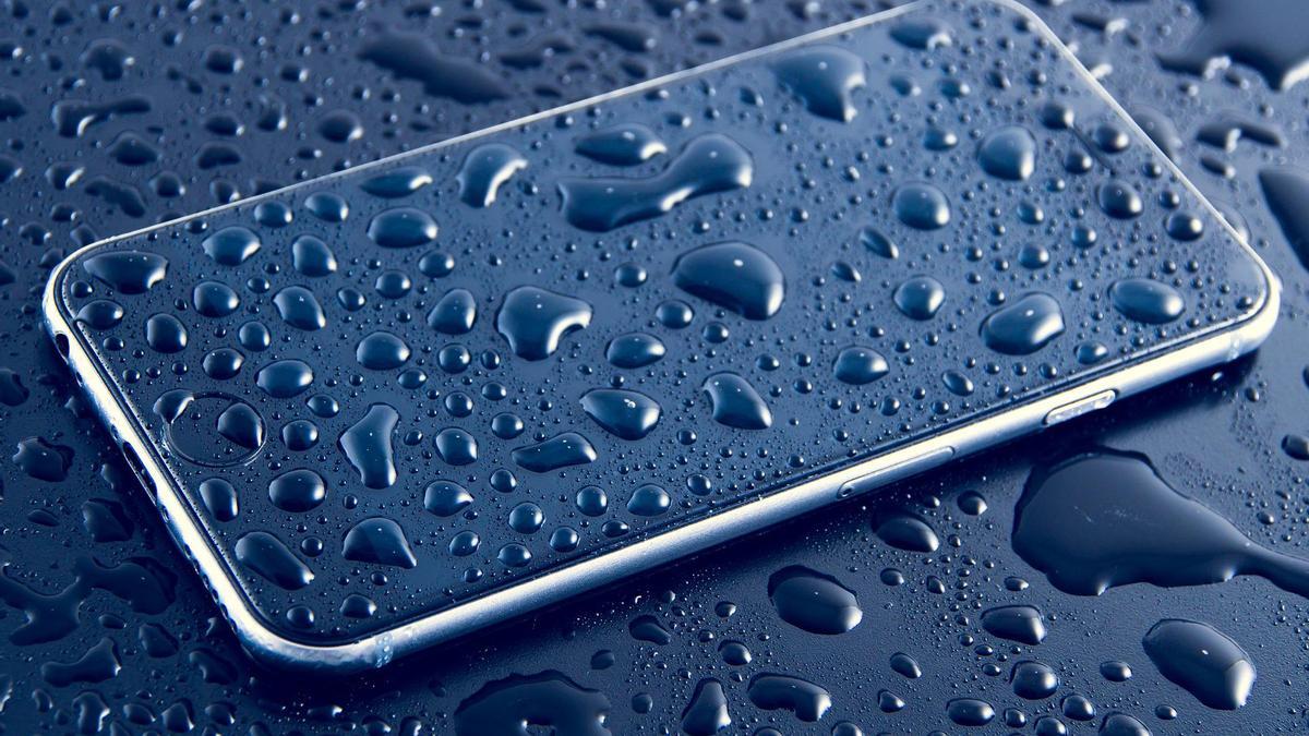 Un teléfono móvil cubierto de gotas de agua.