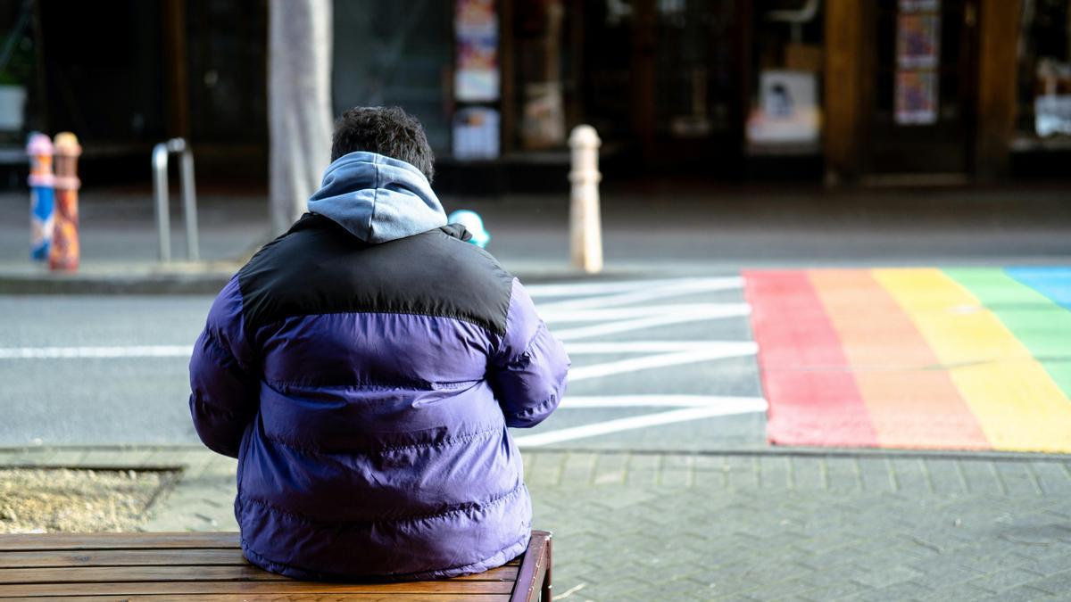 Una persona sentada en una banca.