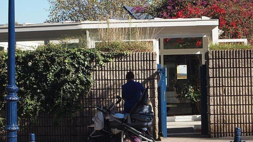Una mujer espera en la puerta de la guardería.