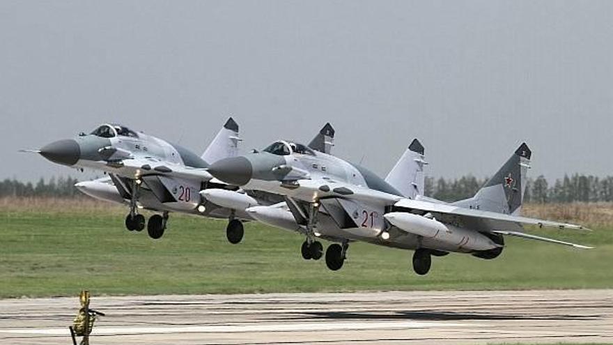 Dos aviones de combate de la serie MiG-29 toman tierra en formación durante un ejercicio.