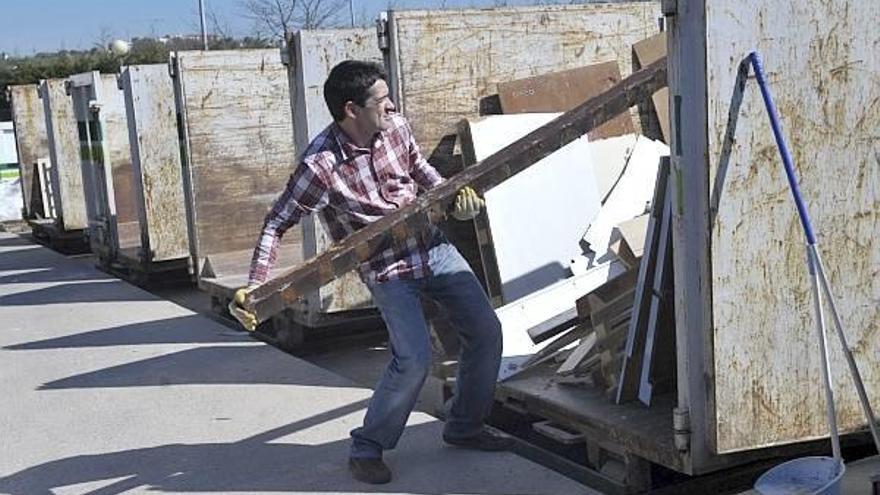 Un ciudadano deposita en uno de los contenedores del garbigune de Erandio un listón de madera.