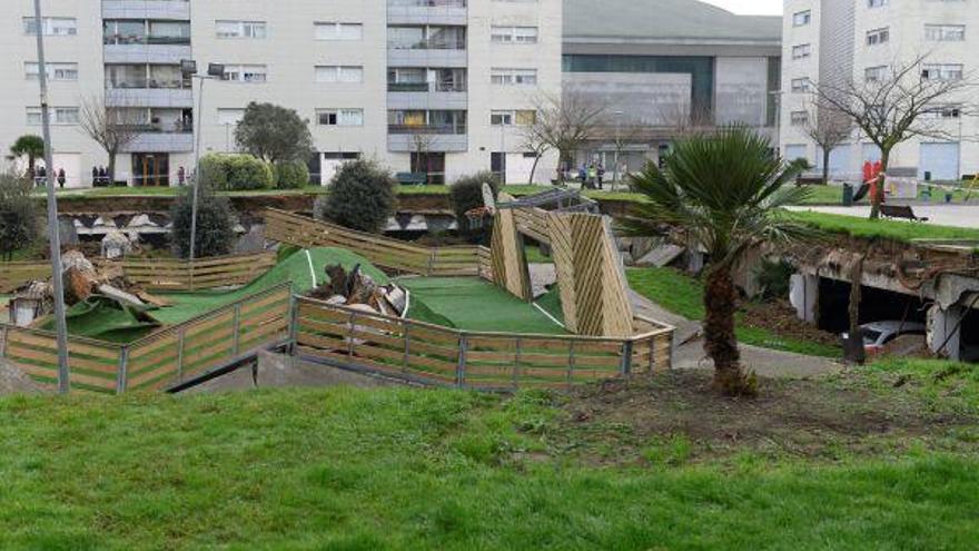 Vista de la zona del parque infantil y la pista deportiva que se ha hundido sobre un aparcamiento.