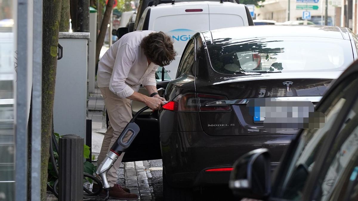 Una persona recarga su coche eléctrico.