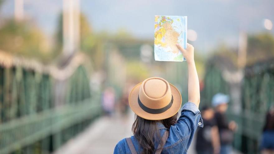 Una mujer sostiene un mapa durante un viaje.