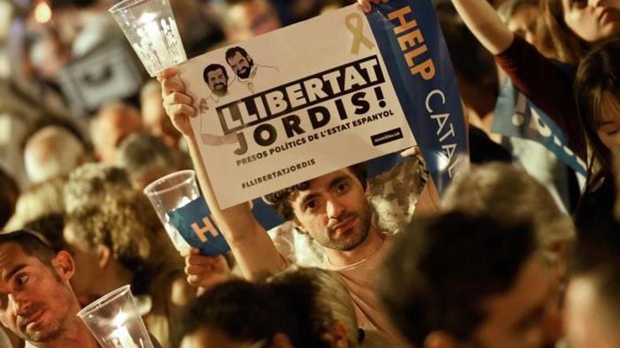 Un hombre sostiene un cartel para pedir la libertad de los Jordis.