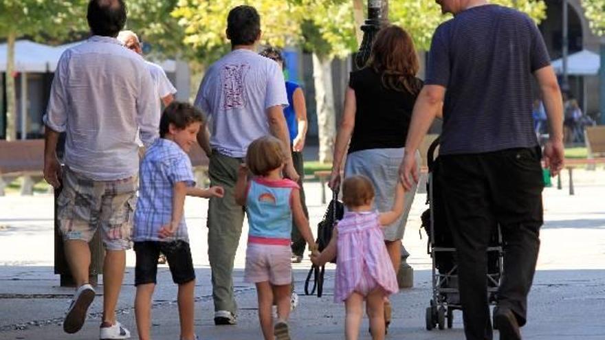Padres y madres paseando con sus hijos.
