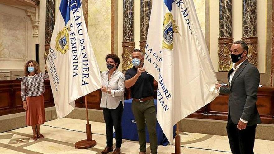 Nekane Arzallus, teniente de alcalde del Ayuntamiento de Donostia, el concejal Martin Ibabe y representantes de EKP y Adegi, con las banderas. Foto: N.G.