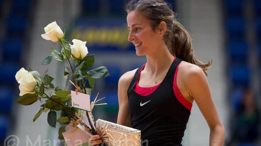 Ana Llorens recibe el ramo de flores en mitad del polideportivo Anaitasuna.