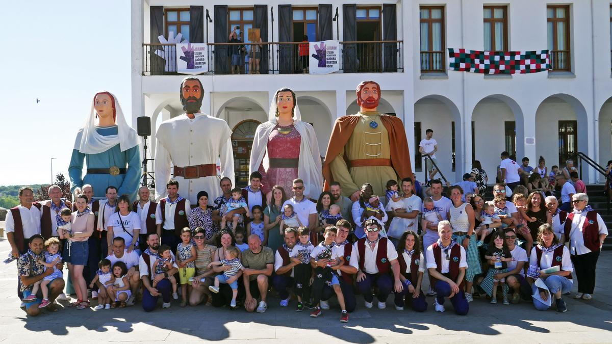 Foto de familia de los niños y niñas nacidas en 2024 con los gigantes y miembros de la comparsa.
