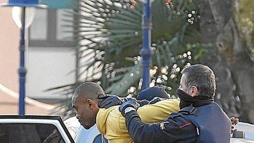 Un ertzaina introduce al detenido en el coche.