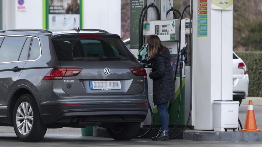 Una mujer reposta combustible en una gasolinera.