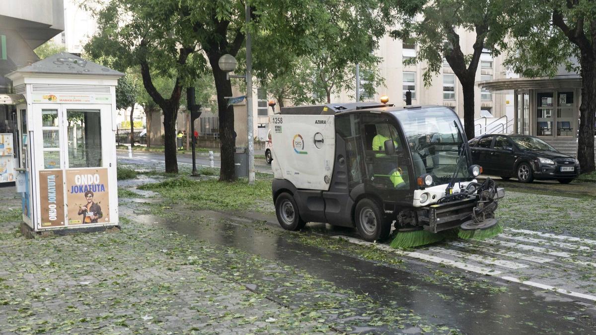Una barredora barre la calle, tras una granizada en Vitoria.