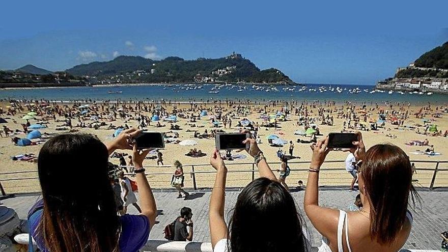 Etxeko ataritik turistei begira