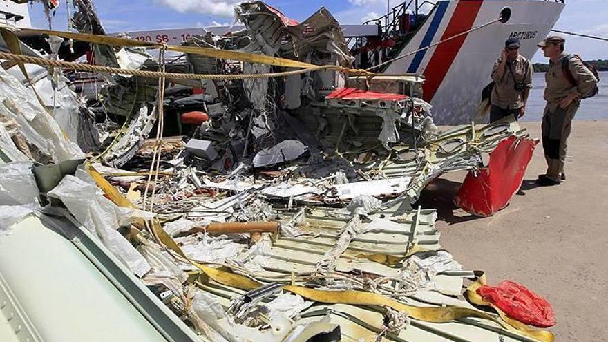 Dos investigadores revisan los restos del avión de AirAsia QZ8501 durante la misión de recuperación de los restos en Panglima Utar Kumai en Borneo