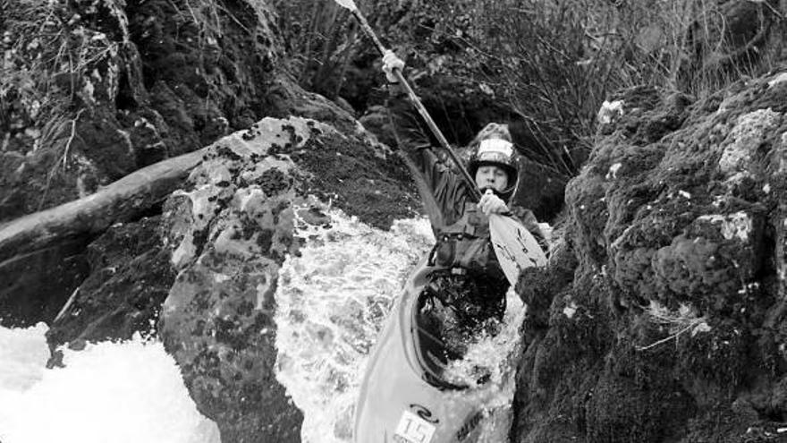 Un hombre desciende en kayak por uno de los rápidos del río Urederra.