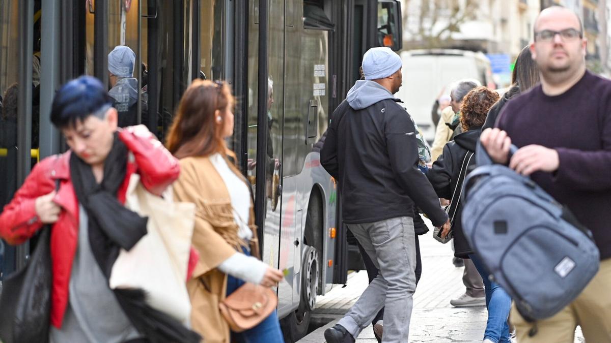 Varias personas descienden de un autobús en una parada