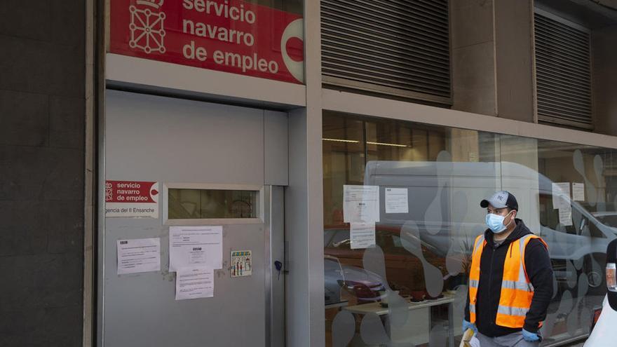 Un hombre protegido con mascarilla por la pandemia de coronavirus pasando junto a la oficina del Servicio Navarro de Empleo