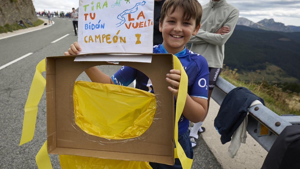 Un niño posa con un mensaje para los ciclistas.