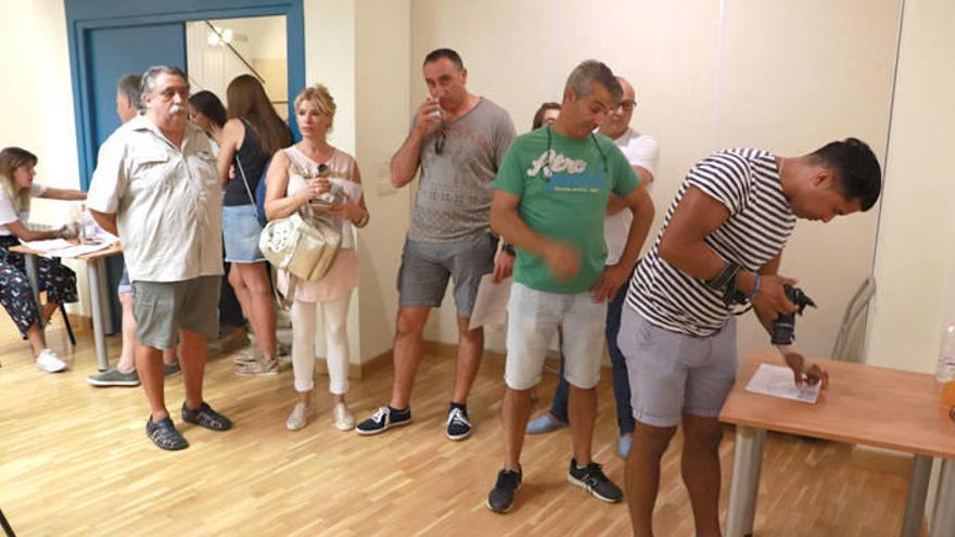 Asistentes al casting aguardan su turno para ser fotografiados por un miembro del equipo.