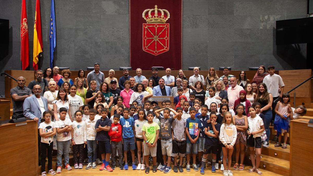Fotografía de grupo de los niños acogidos en Navarra, las familias de acogida, miembros de asociaciones vinculadas al Sáhara y parlamentarios en la Cámara Foral.