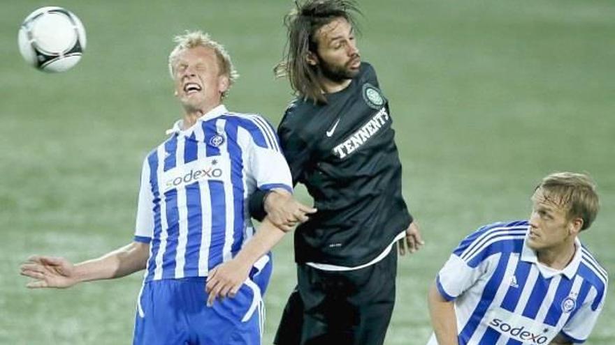 El finlandés Mathias Lindiström, defensa del HJK Helsinki, pugna por el balón con Giorgos Samaras durante el partido de vuelta de la previa de la Champions