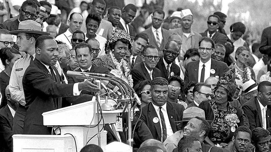 Martin Luther King, durante su discurso junto a Mahalia Jackson, a su izquierda vestida con un gorro negro.