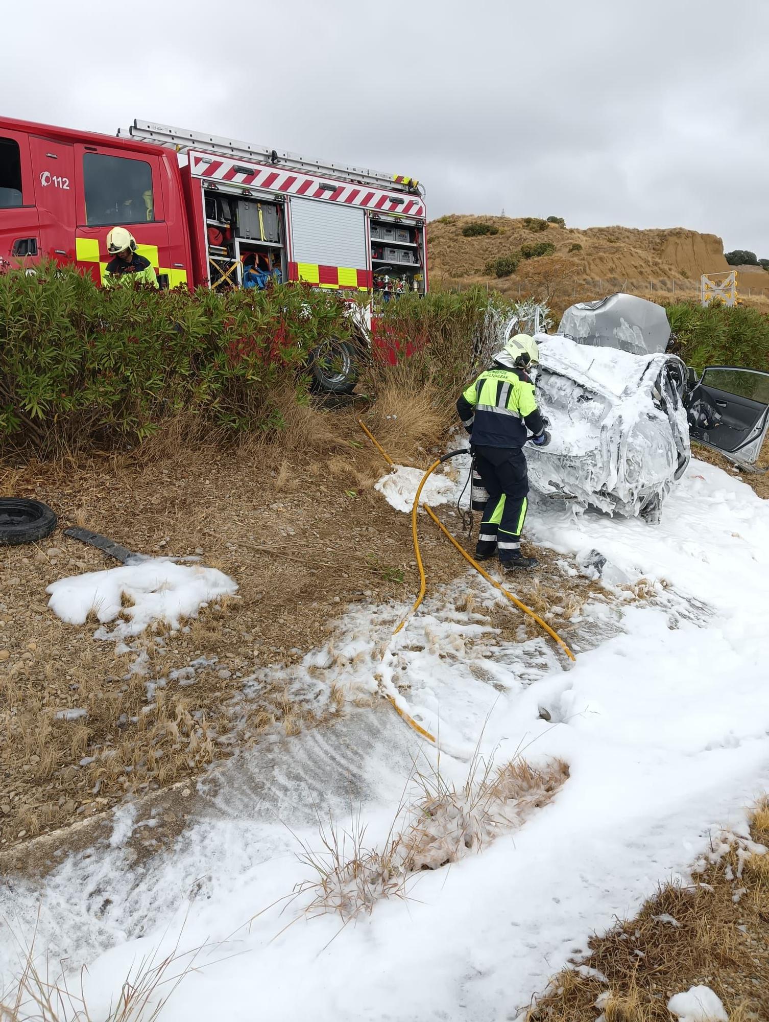 Bomberos de Navarra tras sofocar el fuego en el vehículo accidentado.