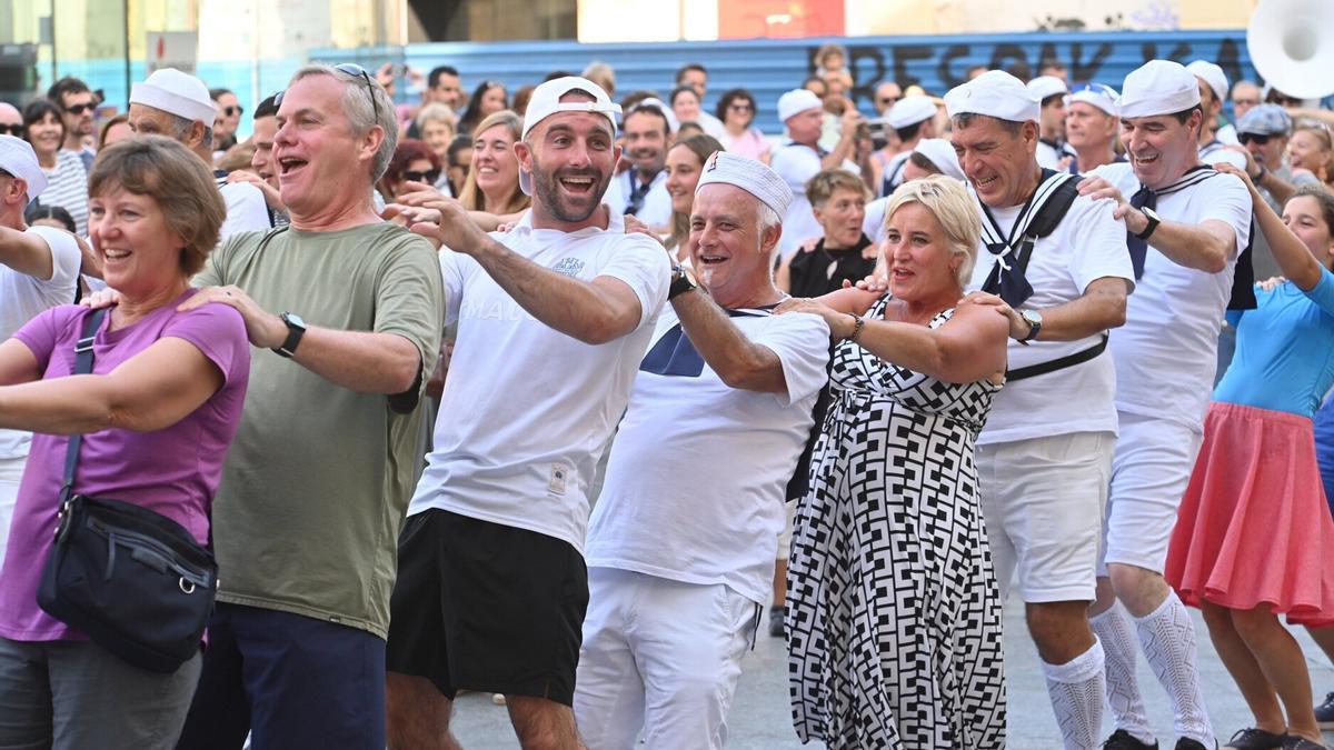Miembros de la fanfarre Bebés de la Bulla bailando junto a numerosos espectadores