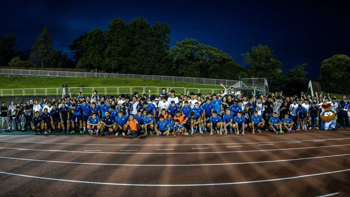 La plantilla de la Real Sociedad posa con aficionados locales al término del entrenamiento de Yokohama