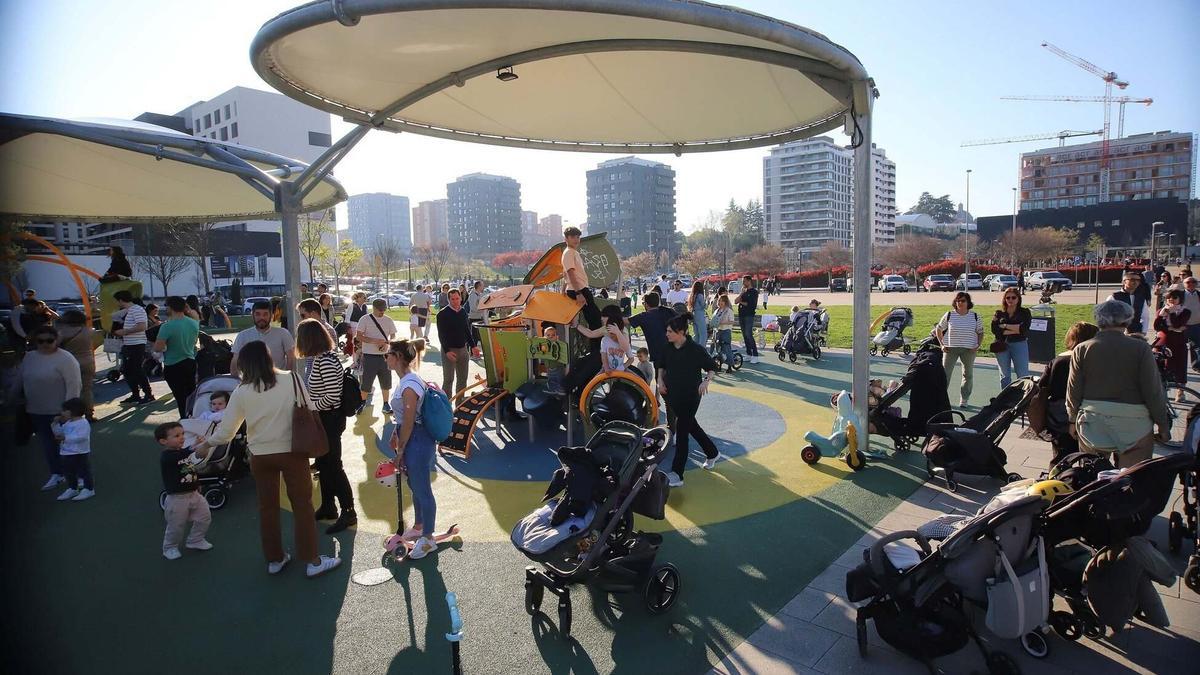 Un parque infantil repleto de gente en un día primaveral en Pamplona.