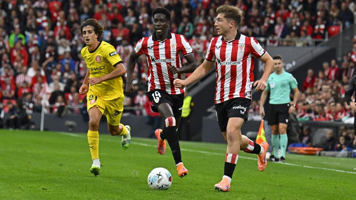 Mikel Jauregizar conduce el balón ante el Girona con Adama Boiro a su lado.