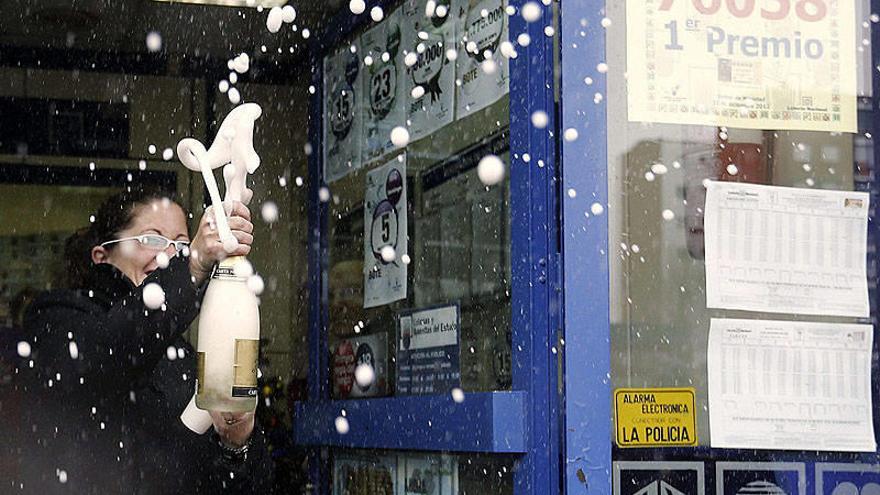 Algunos de los premiados por el Gordo de la lotería de Navidad festejan con botellas de champán su fortuna.