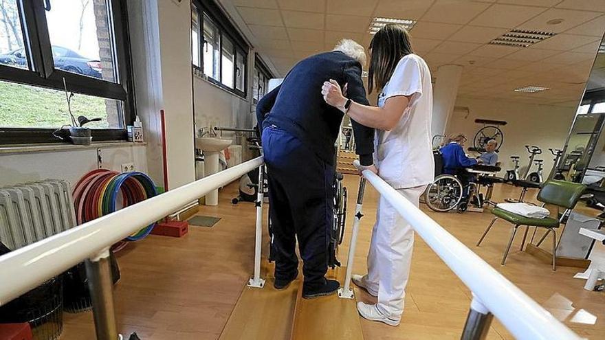 Una cuidadora ayuda a un anciano en una residencia para mayores.  | FOTO: EUROPA PRESS