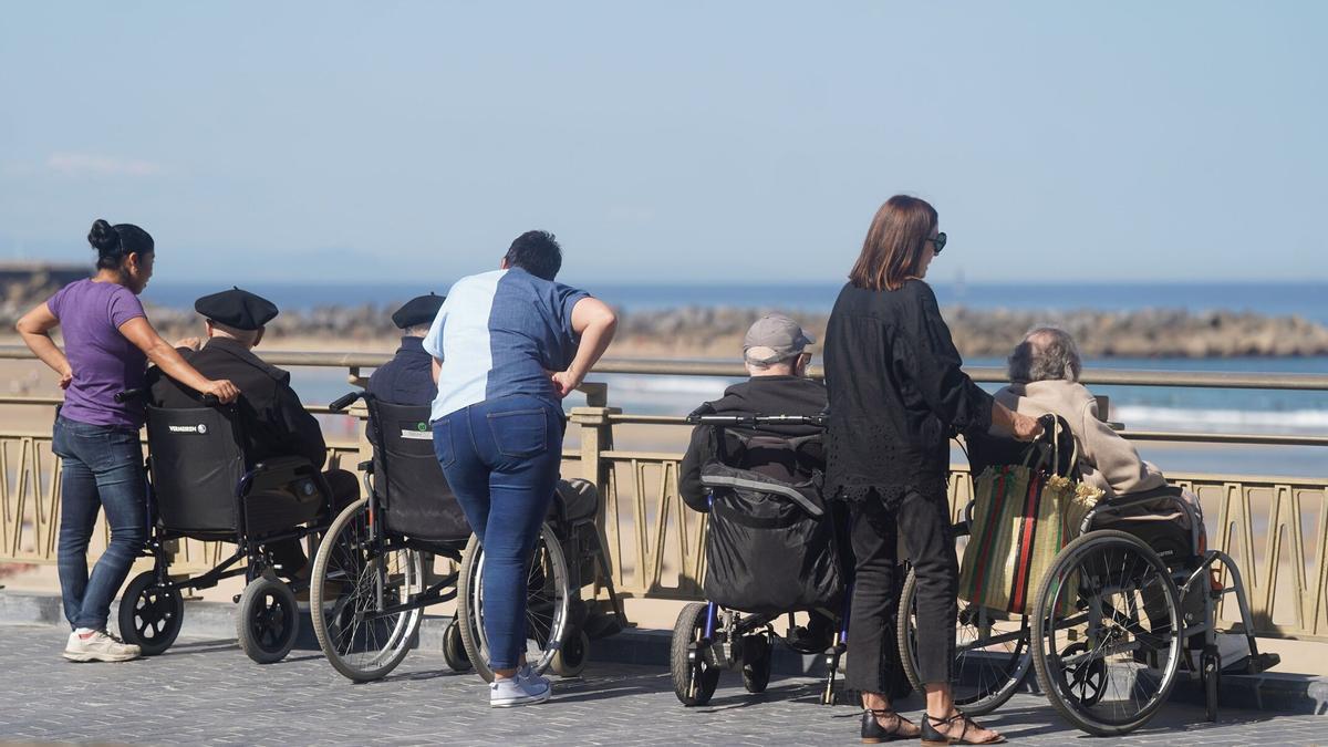 Un grupo de personas mayores se asoman al mar en La Zurriola