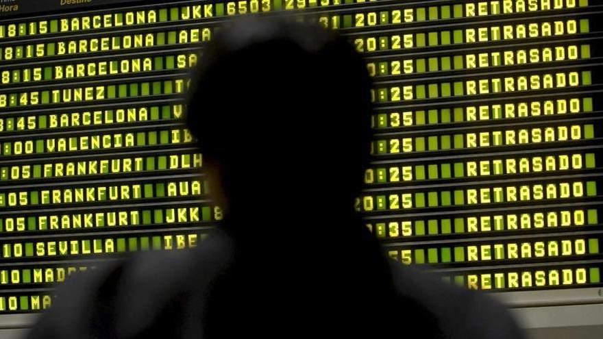 Un hombre consulta el panel de salidas en un aeropuerto.