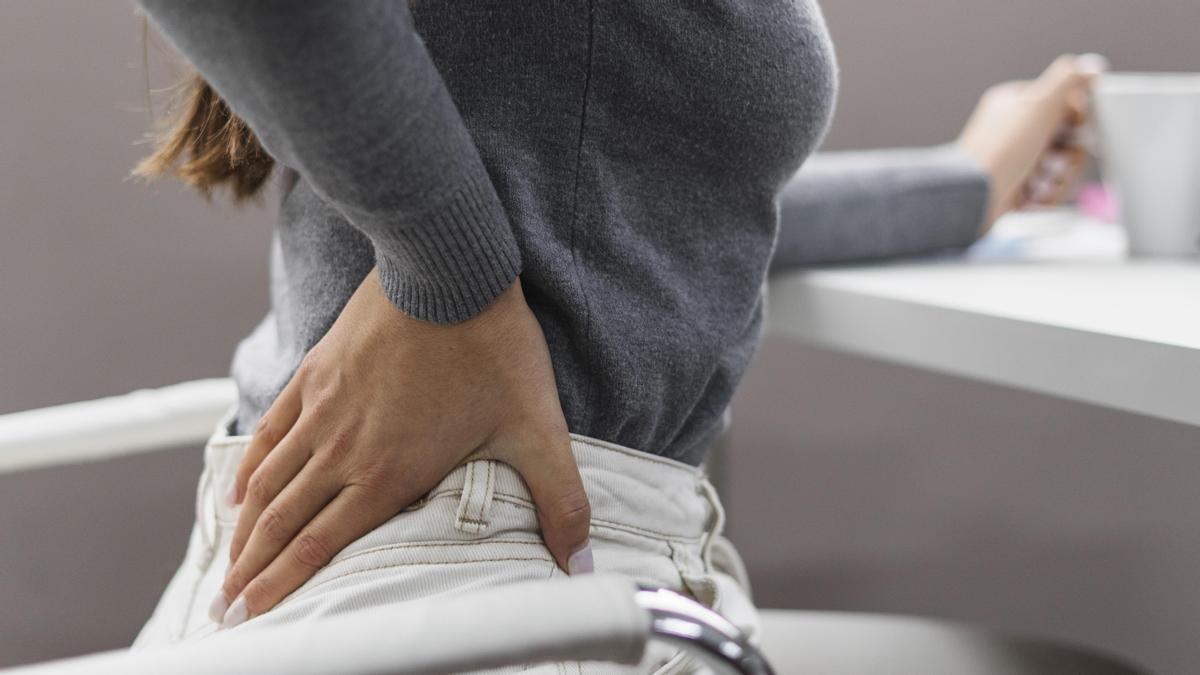 Una persona sufriendo dolor de espalda.