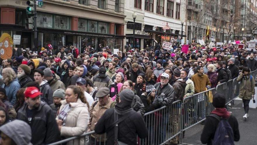 Cientos de personas se manifiestan con pancartas durante una protesta cerca de una de las rutas del desfile de investidura de Donald J. Trump como 45º presidente de los Estados Unidos en Washington DC.
