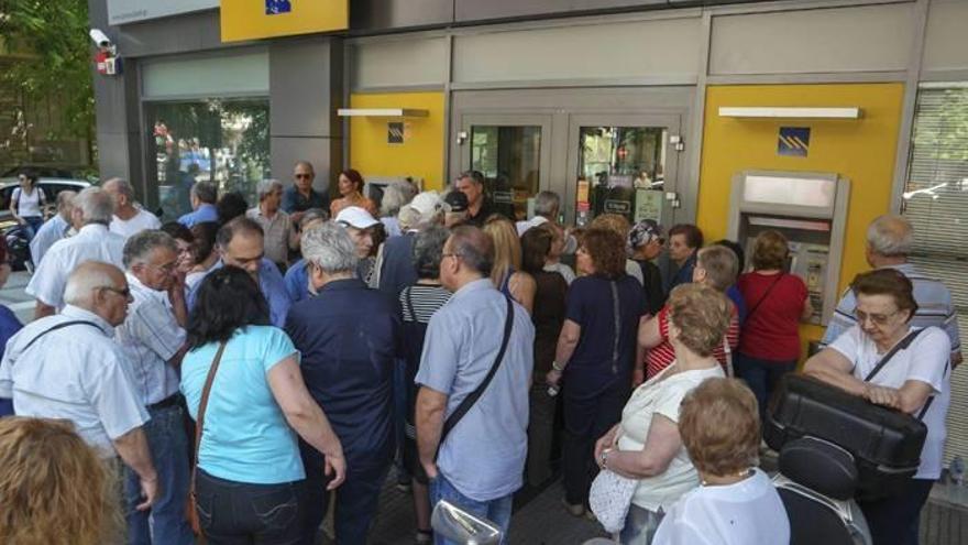 Pensionistas haciendo cola para retirar dinero del banco.