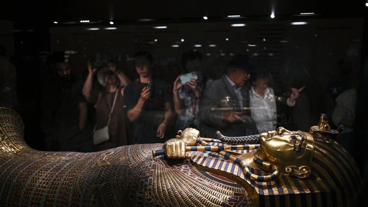 Los visitantes contemplan el ataúd de oro del antiguo faraón egipcio Tutankamón.