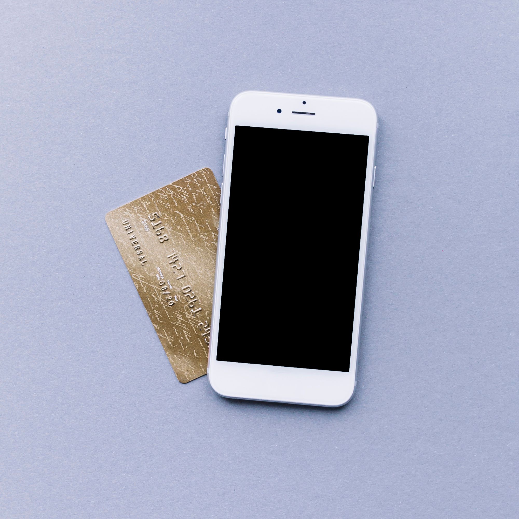 Una tarjeta bancaria debajo de un teléfono movil.