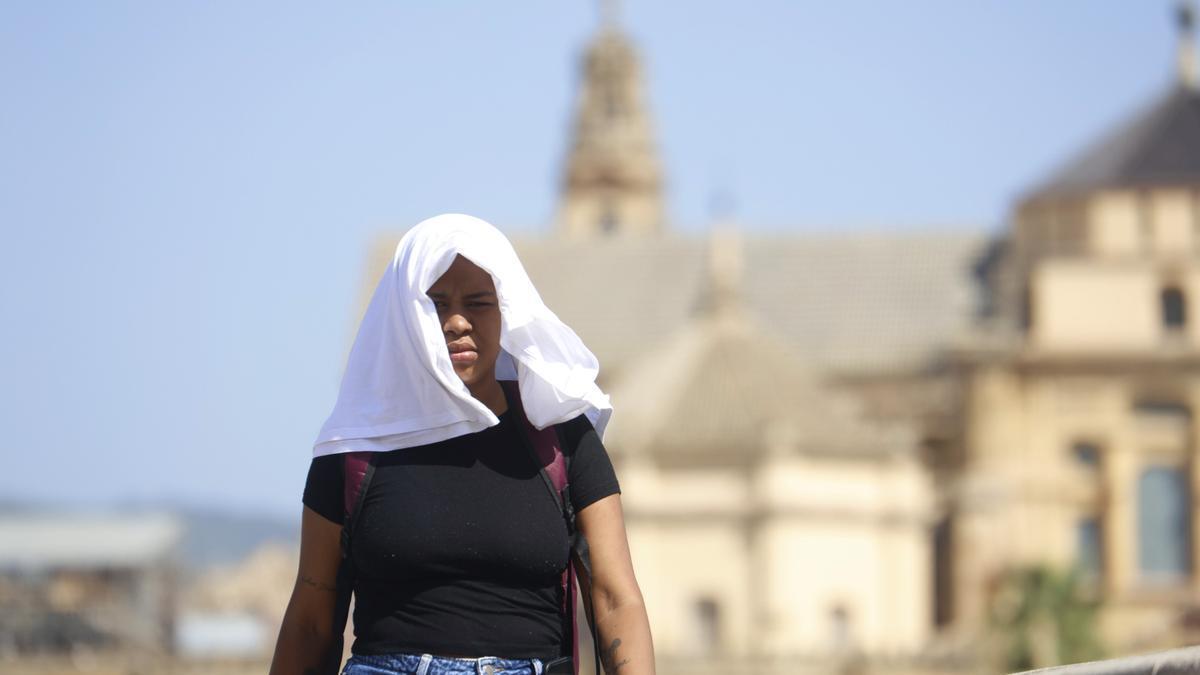 Una mujer se tapa con una camiseta mientras camina por Córdoba durante un día de 40 grados.
