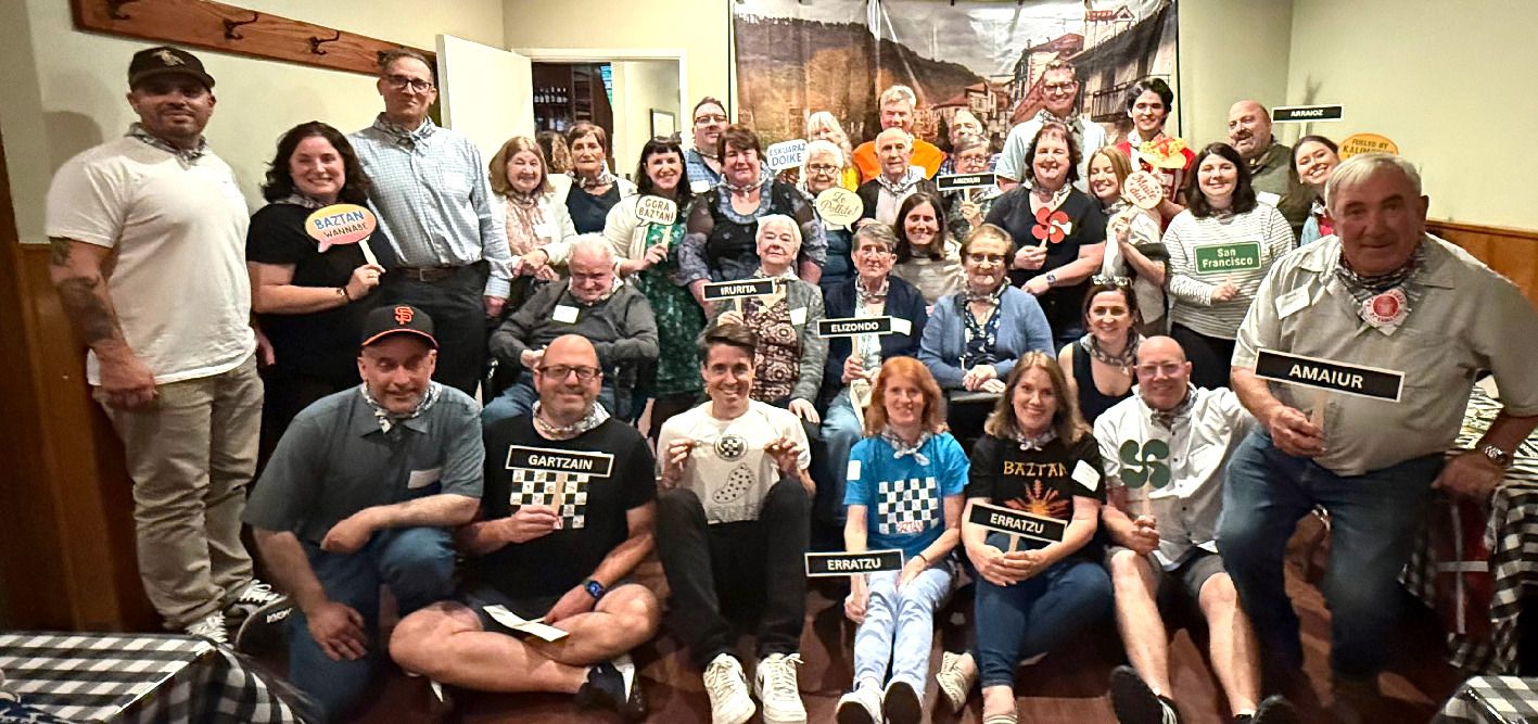 Grupo de Baztandarras nacidos en el valle y descendientes posan orgullosos con los nombres de sus pueblos de origen antes de la comida