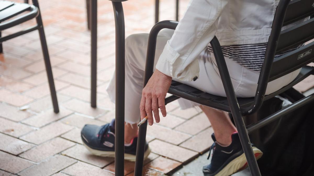 Una persona fuma un cigarrillo en una terraza de Donostia.