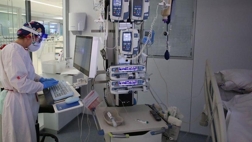 Una enfermera registra los datos de un paciente con respirador ingresado UCI del CHN.