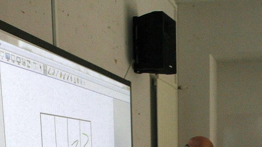 Detalle de la pizarra, con un alumno realizando un ejercicio.