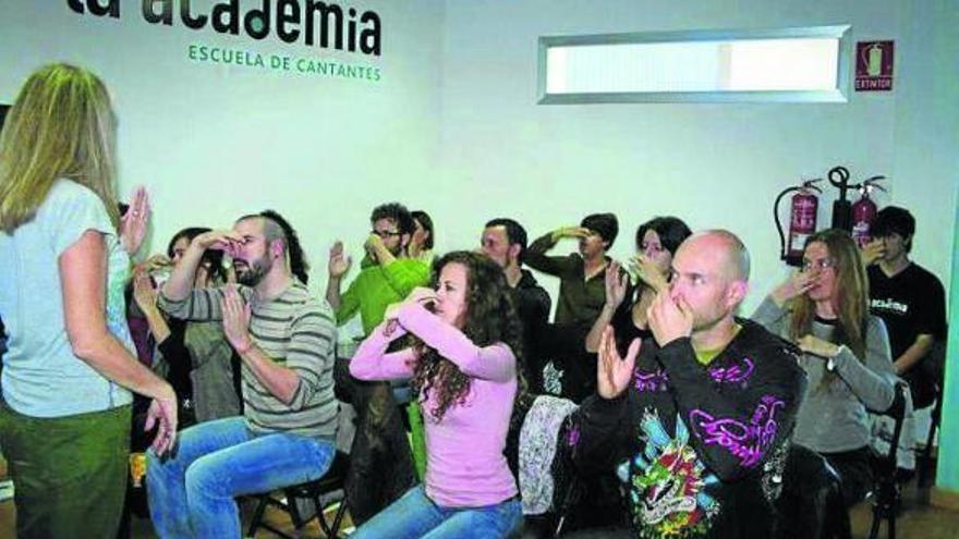 Alumnos asisten a una de las clases de canto y control de voz de la academia.