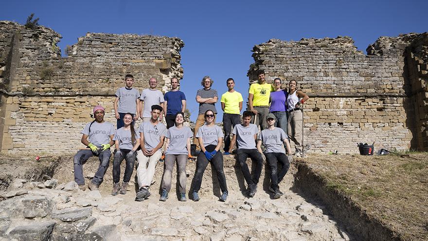 Estudiantes, personas voluntarias y responsables del campo arqueológico posan delante del Castillo de Tiebas.