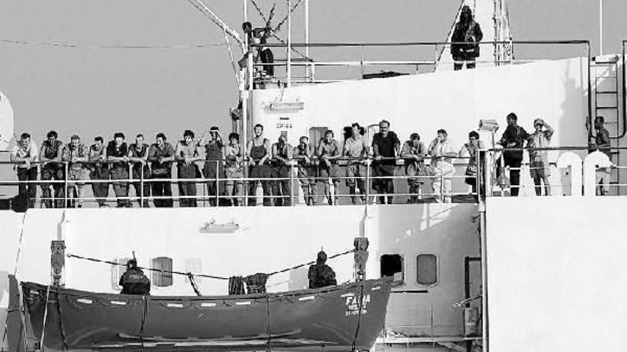 Tripulantes del mercante &quot;Faina&quot;, que estuvo secuestrado más de tres meses, permanecen en la cubierta junto a algunos de los piratas.